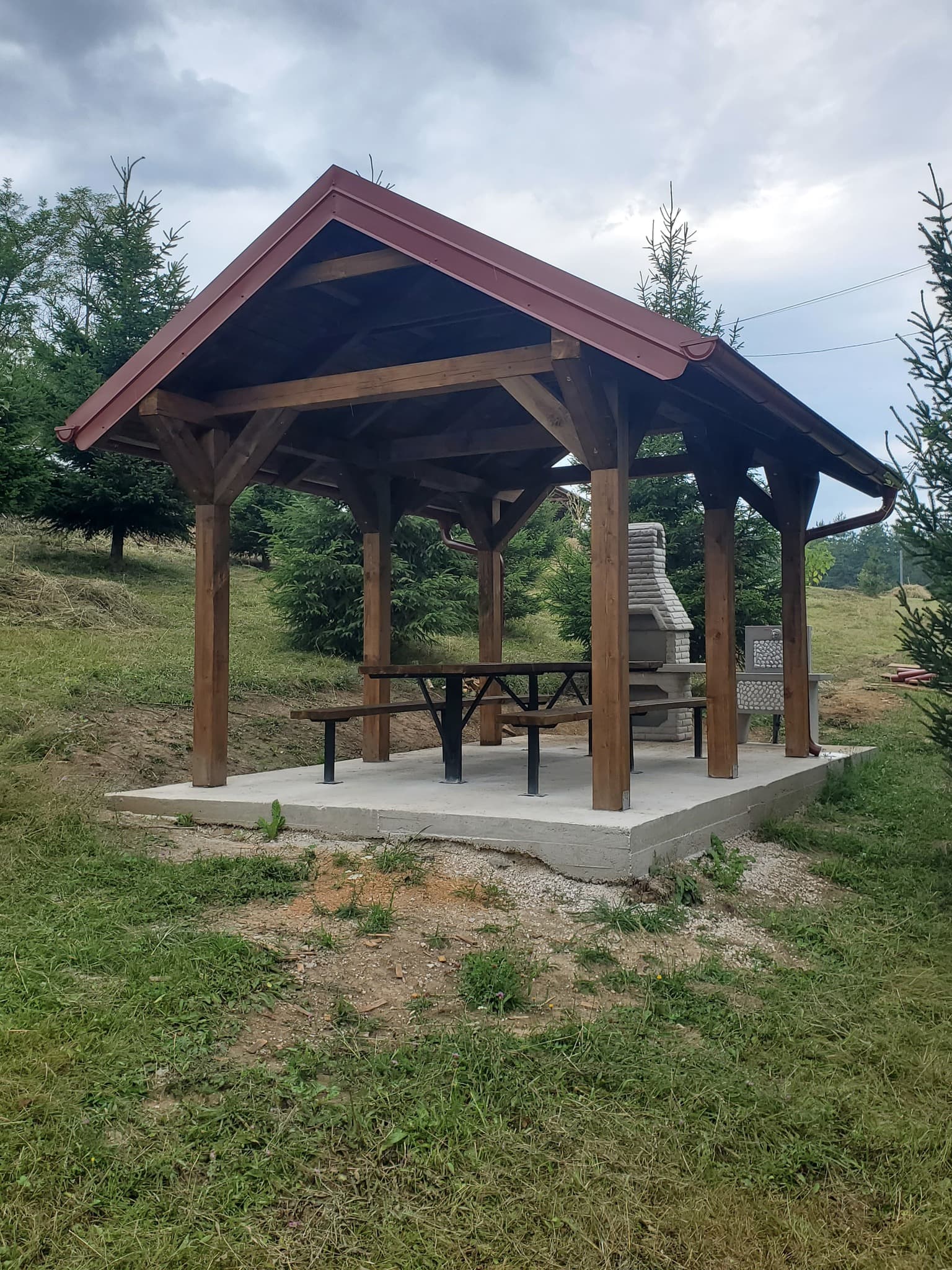 Nova drvena nadstrešnica sa crvenim krovom